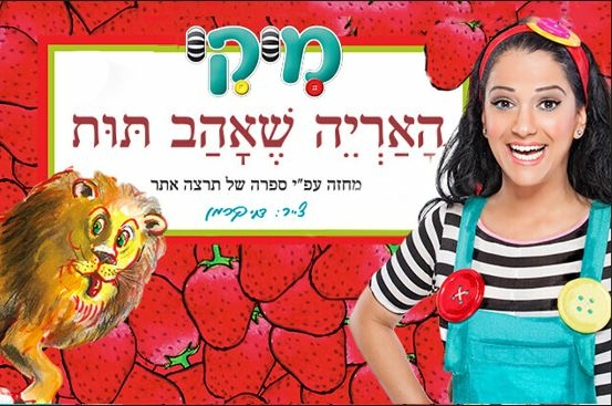 תמונת מופע: כוכבת המופע מיקי מחייכת עם ידיים על המותן מאחוריה המון תותים ואריה עם הלשון בחוץ