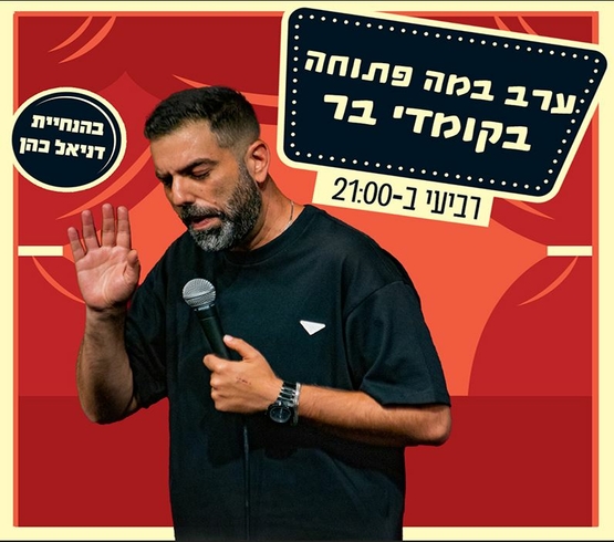 תמונת מופע: תמונה של דניאל כהן אוחז במיקרופון ומרים את ידו