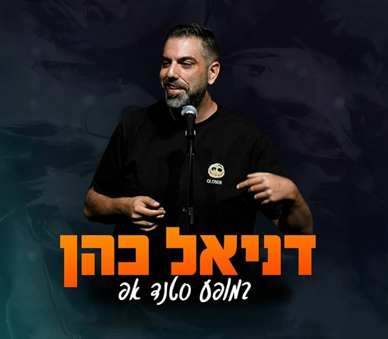 תמונת מופע: דניאל כהן עומד מול מיקרופון מחוייך