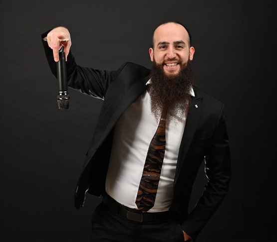 תמונת מופע: תמונה של הרב יעקב חמו מחזיק מיקרופון הפוך